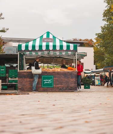 3x3 m folding gazebo at the weekly market. The folding gazebo is fully printed, has various side walls and a counter. It serves as a sales stand for fruit and vegetables.