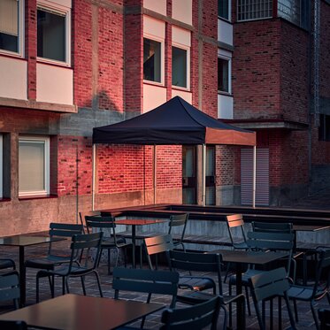 Der schwarze 3x3 m Faltpavillon dient als Outdoor-Überdachung auf der Terrasse.