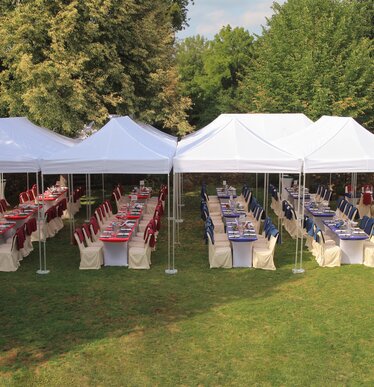 Zwarte 3x3 m gazebo met 2 gesloten zijwanden en een panoramavenster, gepersonaliseerd met Hannibal Gin logo, gebruikt voor ginverkoop op een straatje.
