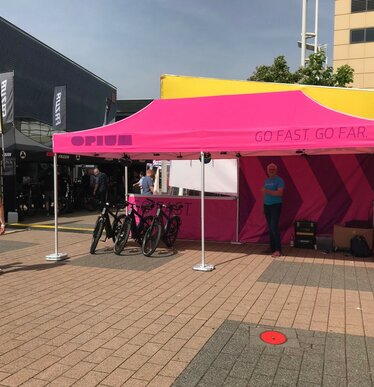 Donkergrijze 6x4 m opvouwbare motorsport gazebo gepersonaliseerd met Flex, gebruikt als paddock voor een rode auto. Ecotent