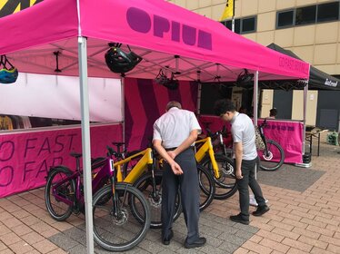 Fuchsia 6x3 m opvouwbare gazebo gepersonaliseerd met Opium logo en verschillende zijwanden op Eurobike in Zwitserland, gebruikt als fietsstand.