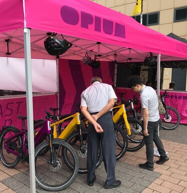 Fuchsia 6x3 m opvouwbare gazebo gepersonaliseerd met Opium logo en verschillende zijwanden op Eurobike in Zwitserland, gebruikt als fietsstand.